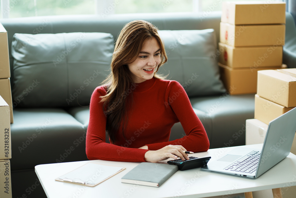 The small business owner smiles and writes information on the parcel, Online trading ideas and product delivery. The small business owner smiles and writes information on the parcel, Online trading ideas and product delivery.