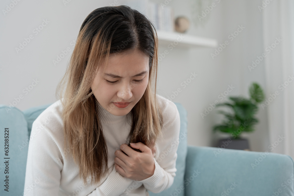 hand hold chest with heart attack symptoms, asian woman have chest pain caused by heart disease, leak, dilatation, enlarged coronary heart, press on the chest with a painful expression hand hold chest with heart attack symptoms, asian woman have chest pain caused by heart disease, leak, dilatation, enlarged coronary heart, press on the chest with a painful expression