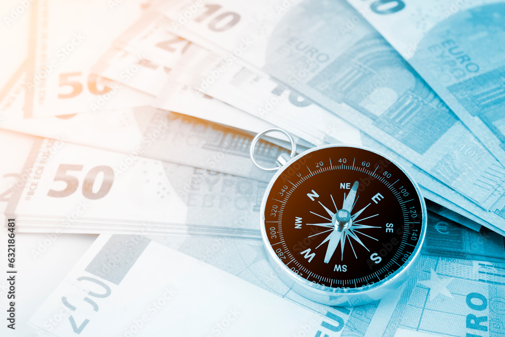 The Compass on top of Assorted denominations of Euro bills. Business concepts. The Compass on top of Assorted denominations of Euro bills. Business concepts.