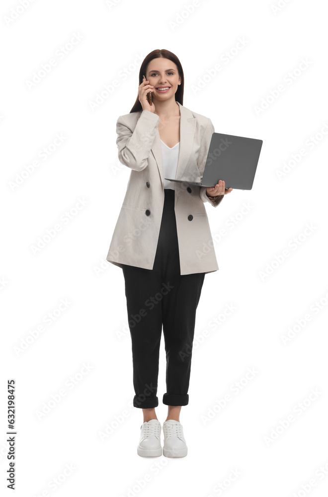 Beautiful businesswoman in suit with laptop talking on smartphone against white background Beautiful businesswoman in suit with laptop talking on smartphone against white background