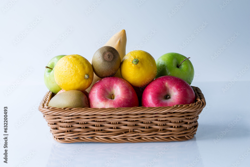 Assorted fresh mix fruits in a rectangle basket on white background, concept fruit in shop and supermarket..