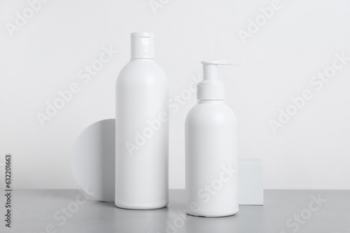 Bottles of cosmetic products on grey table