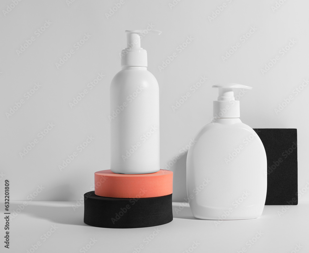 Bottles with different cosmetic products and podiums on white background Bottles with different cosmetic products and podiums on white background
