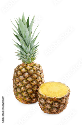 Whole and cut tasty ripe pineapples isolated on white