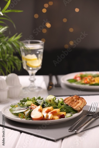 Delicious salad with peach slices served wooden table
