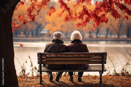 Senior couple sitting on a bench in a autumn park, back view. AI generated