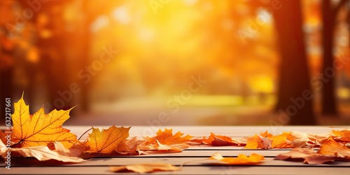 Beautiful orange leaves on a wooden table in the autumn park. Natural autumn background with blur