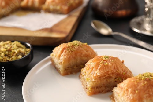 Delicious sweet baklava with pistachios on black table, closeup © New Africa