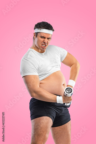 A funny fat man with dubbell isolated on pink background. Obesity and eating disorder. Concept for dietetics and fitness advertising in social networks. photo