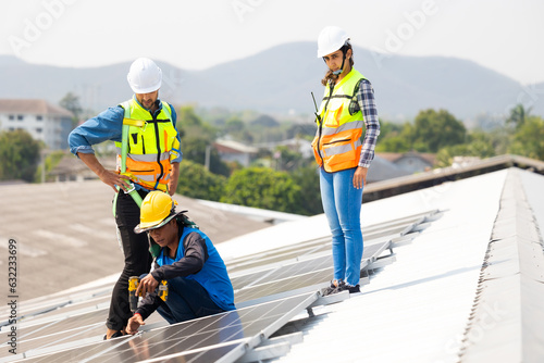 Electrical engineering man using electric hand drill to Installing Solar Cell panels on Roof. Solar energy clean and green alternative energy concept