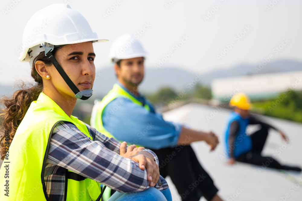 Tired hot wiping sweat. Workers and engineers are sitting and resting from work hard at roof construction site. Hispanic latin woman worker Tired hot wiping sweat. Workers and engineers are sitting and resting from work hard at roof construction site. Hispanic latin woman worker