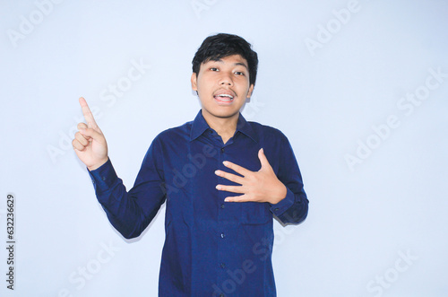 gratefull asian businessman is  smiling after suffering from heart attack show presenting gesture with pointing finger up photo