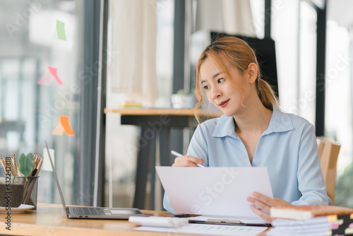 Portrait of confident business woman sitting at the table and working on the laptop.