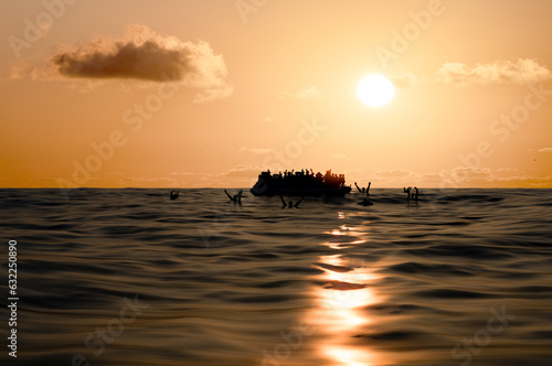 Φωτογραφία Refugees on a big rubber boat in the middle of the sea that require help