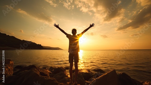 Boy s silhouette in sunset over sea representing religion worship prayer and praise
