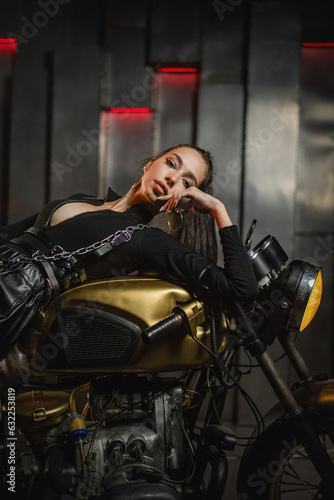 Young beautiful girl with dark hair on the old motorbike.