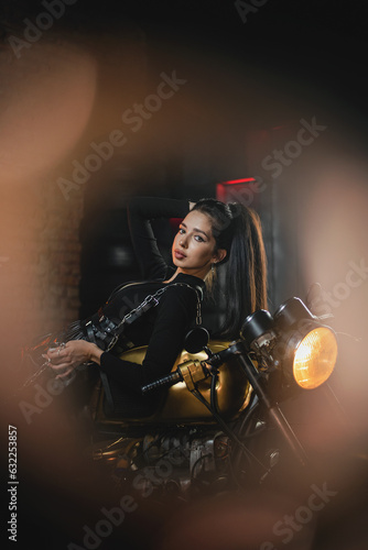 Young beautiful girl with dark hair on the old motorbike.
