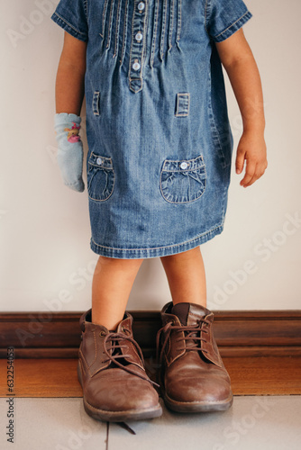 girl playing with daddy's shoes