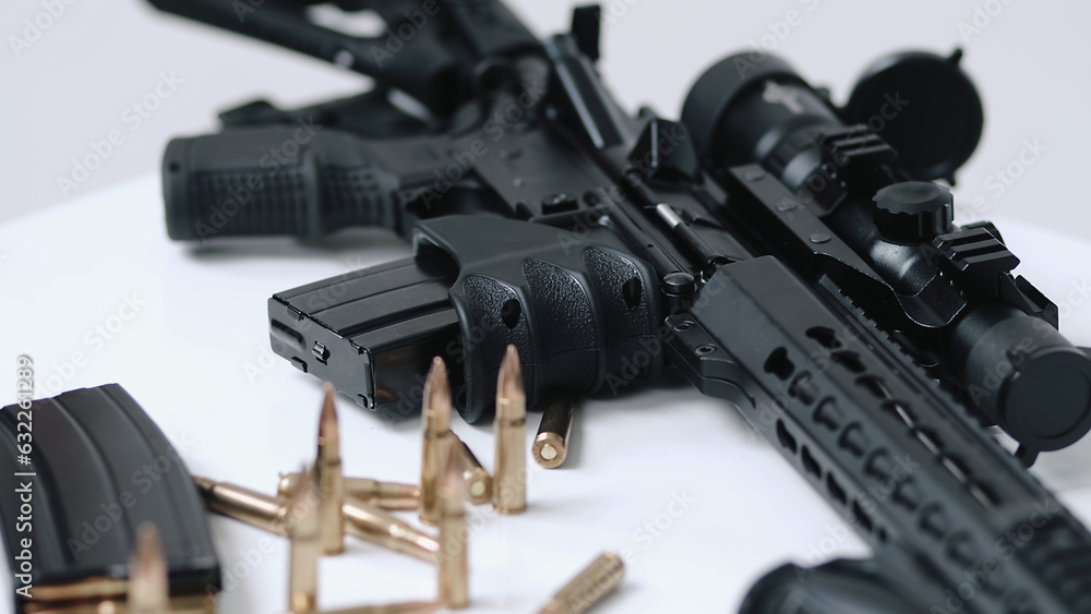 High angle dolly in towards loaded assault rifle with a small amount of ammunition in the foreground. military target, war, bullet weapon, army military firearm, bunch of bullets, bullet shells, milit High angle dolly in towards loaded assault rifle with a small amount of ammunition in the foreground. military target, war, bullet weapon, army military firearm, bunch of bullets, bullet shells, milit