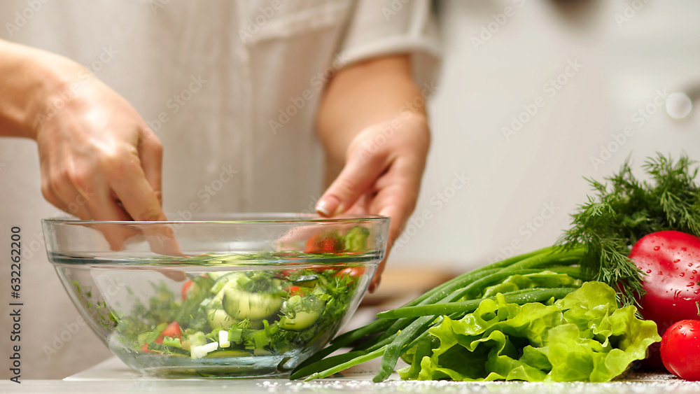 Salt the vegetables salad slow motion. Making vegetable salad outdoors. Cooking salad from fresh raw vegetables - tomatoes, cucumbers, greens, pepper, scallion, onion, olive oil. Outdoors Salt the vegetables salad slow motion. Making vegetable salad outdoors. Cooking salad from fresh raw vegetables - tomatoes, cucumbers, greens, pepper, scallion, onion, olive oil. Outdoors