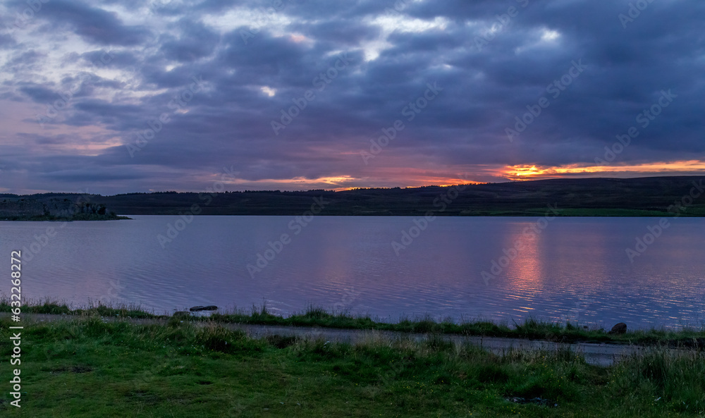 Sunset over Lochindorb and Lochindorb castle with reflection on the water of the loch
