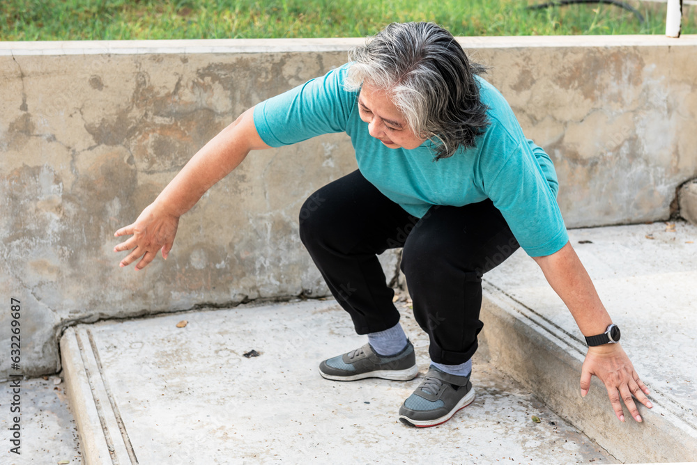 Asian elderly woman trying hard to get up because of a knee injury from arthritis of the knee. to elderly woman and rheumatoid arthritis concept.