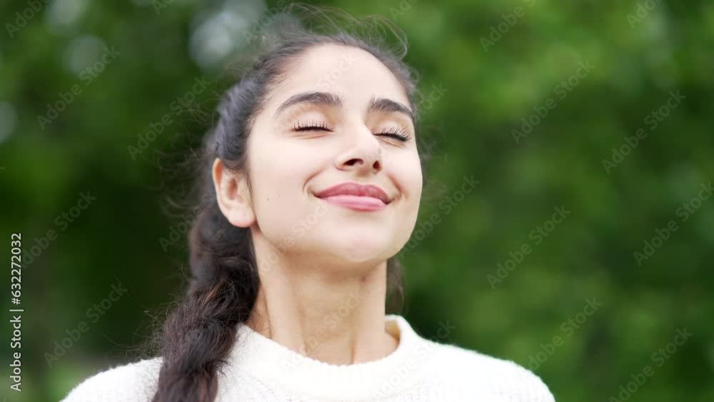 Close up portrait young happy woman standing in nature between forest trees relaxes, breathes fresh air closing his eyes Female enjoys a life of peace calm, quiet in the park. Outdoors. Happiness Close up portrait young happy woman standing in nature between forest trees relaxes, breathes fresh air closing his eyes Female enjoys a life of peace calm, quiet in the park. Outdoors. Happiness