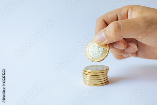 Money in the hands of a woman. Coins of ten Mexican pesos. Savings and economy in Mexico