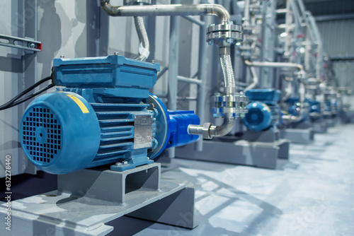 Industrial equipment. Detail of new blue electric motors with pumps on the stainless steel production line. Industrial background. Additive pump station in petrochemical technology. Industrial area..