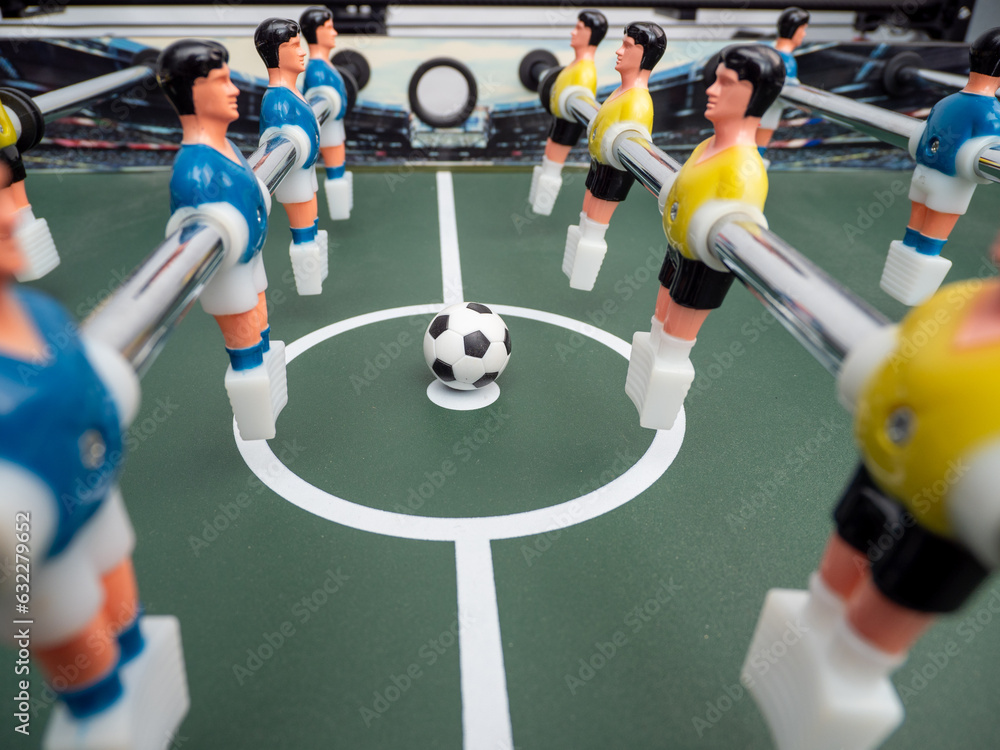 Fototapeta premium A close-up of some players and a soccer ball on a foosball table. Board game football.