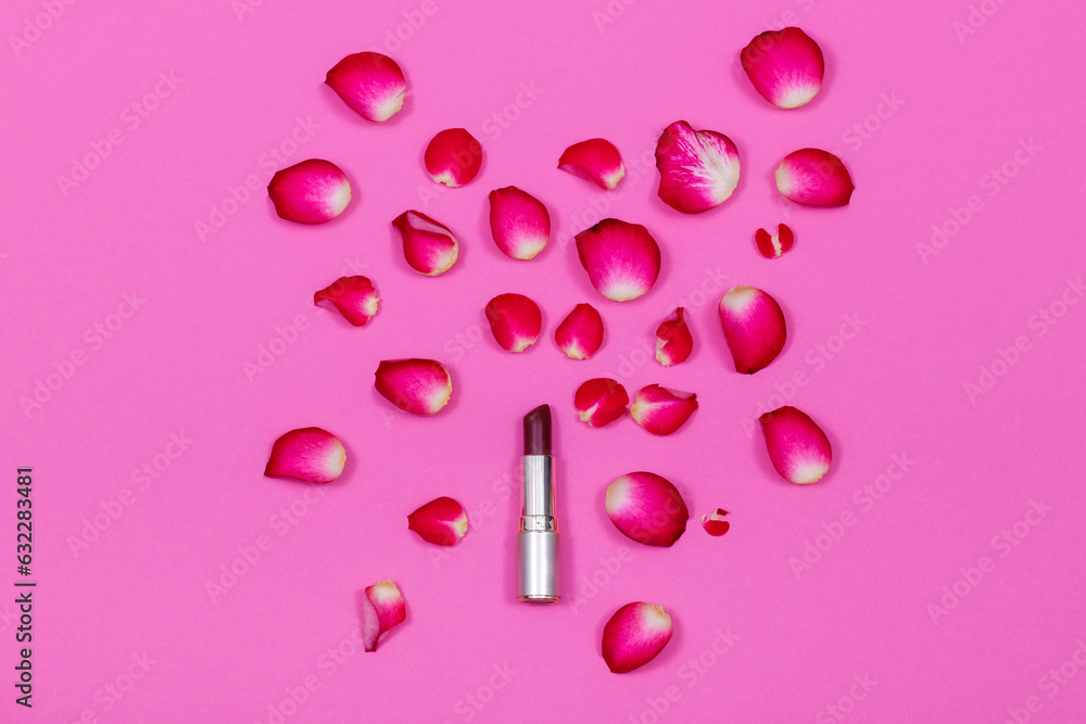 Opened red lipstick on the pink background with rose petals. Scene with empty space. Concept for hollyday card, happy Valentine's day, wedding, Women's or Mother's day. Opened red lipstick on the pink background with rose petals. Scene with empty space. Concept for hollyday card, happy Valentine's day, wedding, Women's or Mother's day.
