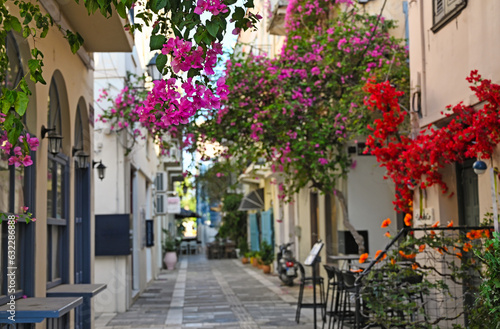 Restaurant and buildings in the narrow streets of Nafplion town with Bougainvillea flowers