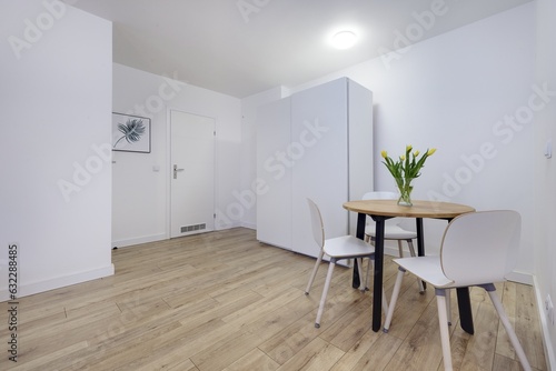 Przedpokój w nowoczesnym apartamecie z białą szafą i meblami © arteffect.pl