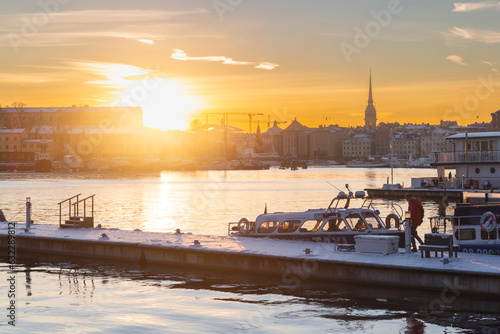 sunset in the bay of Stockholm, where the orange tones of the sun create a warm light on the facades of the buildings that face the bay