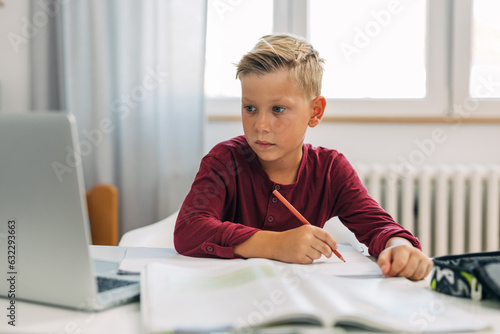 Cute Caucasian boy doing his homework.