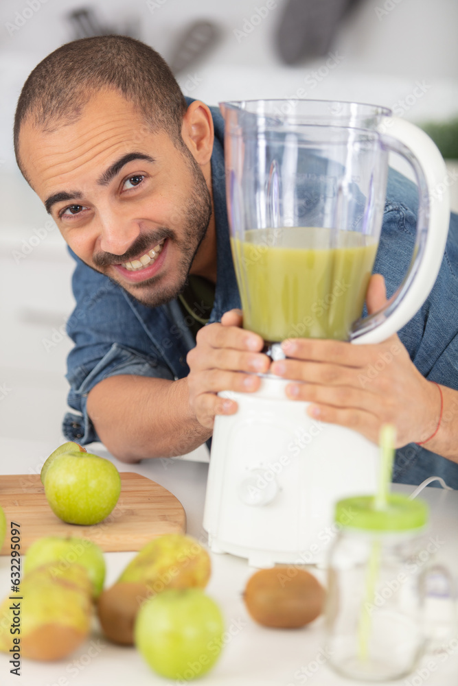 cheerful man juices fruit to make a healthy smoothie cheerful man juices fruit to make a healthy smoothie