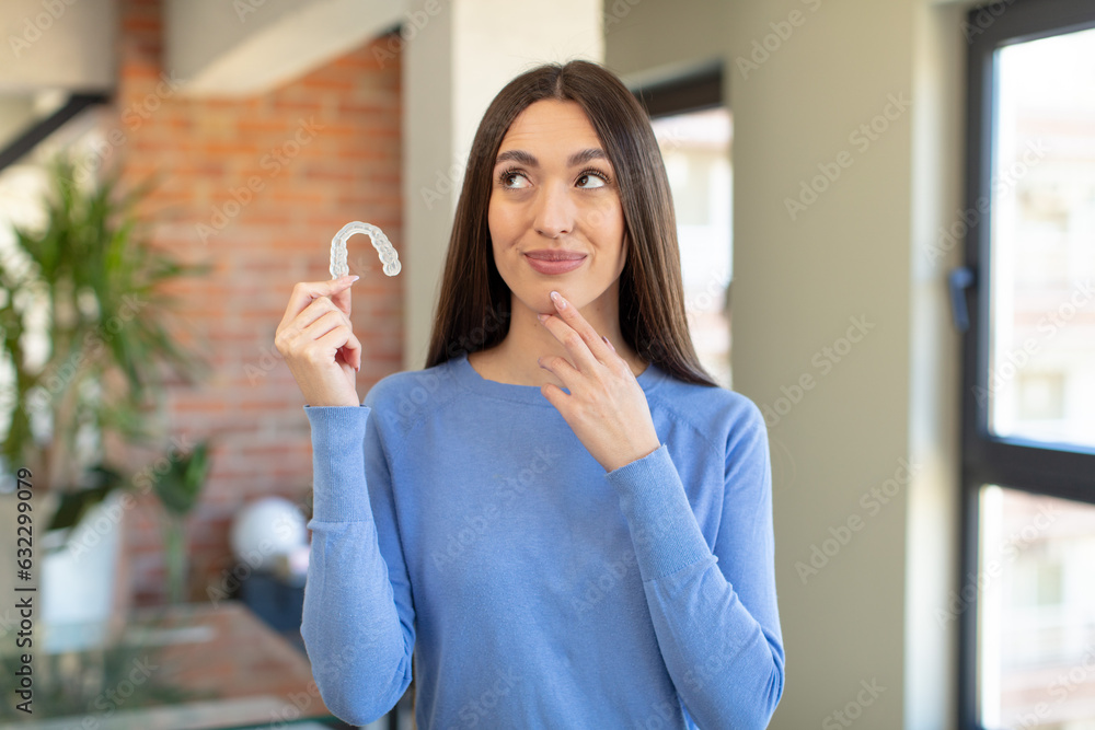 smiling with a happy, confident expression with hand on chin. dental retainer concept smiling with a happy, confident expression with hand on chin. dental retainer concept