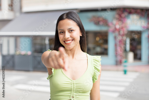 pretty hispanic woman pointing at camera with a satisfied, confident, friendly smile, choosing you © kues1