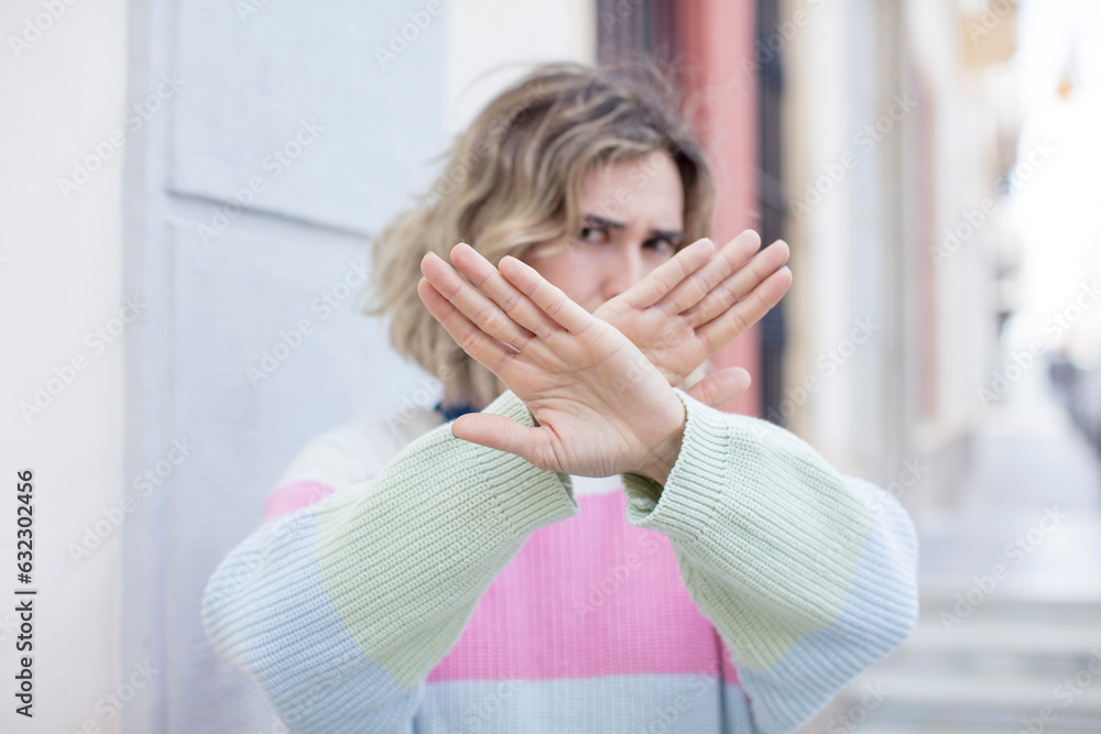 pretty woman covering face with hand and putting other hand up front to stop camera, refusing photos or pictures pretty woman covering face with hand and putting other hand up front to stop camera, refusing photos or pictures