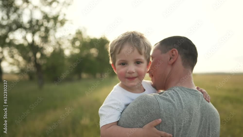 Happy family. Father and son are playing in the park. Baby in the arms of his father. Cheerful baby boy with father walk outdoors in the park. A smile on a child's face. Family team outdoors in park Happy family. Father and son are playing in the park. Baby in the arms of his father. Cheerful baby boy with father walk outdoors in the park. A smile on a child's face. Family team outdoors in park