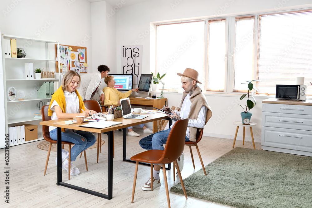 Team of graphic designers working at table in office
