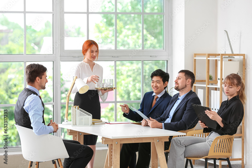 Secretary bringing water on job interview in office Secretary bringing water on job interview in office