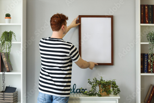 Young redhead man hanging b...
