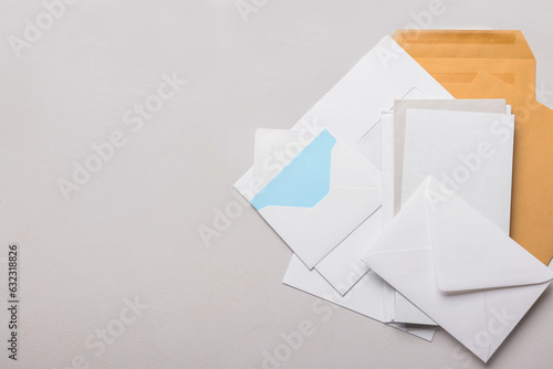 Heap of envelopes and card on light background