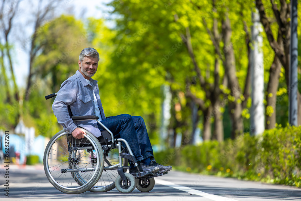 Handicapped man in wheelchair riding on street road, outdoor leisure for disable guy. Handicapped man in wheelchair riding on street road, outdoor leisure for disable guy.