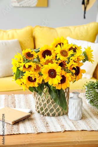 Vase with sunflowers on table in living room