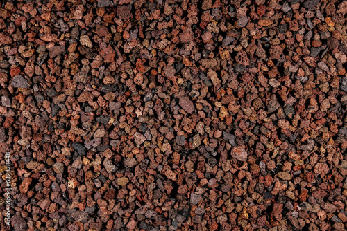 Natural aquarium lava gravel in red brown colors. Volcano lava mulch chippings mineral stones ground