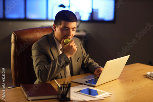 Young businessman eating ap...