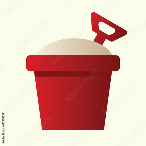 red bucket filled with beach sand with a shovel