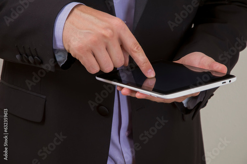Close up view of businessman in business suit using a digital tablet